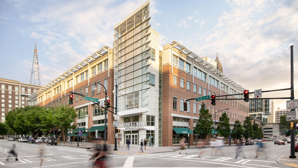 A photo of an intersection at Tech Square, with people walking on the streets.